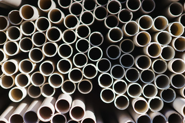 New plastic water pipes laid in a stack in the warehouse. 