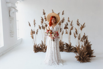 Wedding content - Close up Portrait young beautiful redhair girl in a hat in a studio on a white background with decorations. Copy space