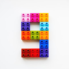 Fototapeta premium Number Nine made of colorful constructor blocks. Toy bricks lying in order, making number 9. Education process - learning numbers with child using multicolored toy details.