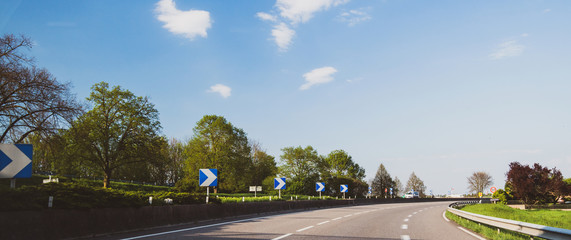 Blue arrows on French autoroute highway with one van driving in background  © ifeelstock