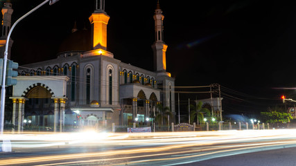 Fototapeta na wymiar A mosque in the junction of the road with light trails of the traffic, Samarinda, Indonesia