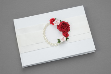 Wedding album decorated with roses and pearls.