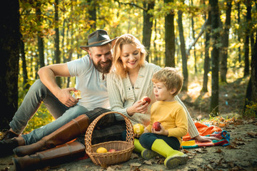 Picnic in nature. Country style family. Meaning of happy family. United with nature. Family day concept. Happy family with kid boy relaxing while hiking in forest. Mother father and small son picnic
