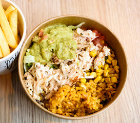 Portuguese pulled chicken bowl with spicy rice and potato fries.