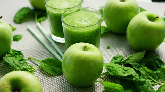 Green smoothie in glasses and ingredients