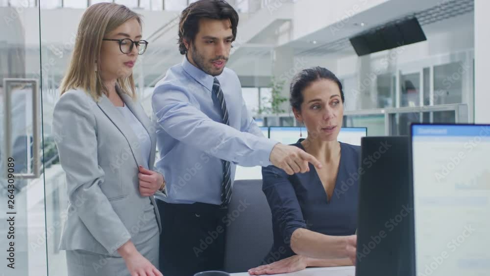 Poster In Bright Modern Office: Office Worker Sitting and Working at Her Desktop Computer, Discusses Problem Solution with Her Project Manager and Team Leader. Young Businessmen Planning and Problem Solving