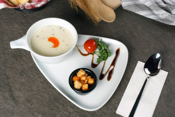 white soup, tadka with cream and parsley on grey stone background