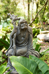 Fototapeta premium stone ruined Arhat statue in forest