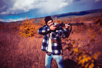 Autumn hunting season. Hunter with shotgun gun on hunt. Hunter with Powerful Rifle with Scope...