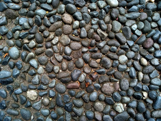 Gravel floor texture background. Floor background with stones. Rocks on the path for health. Round stone floor background.