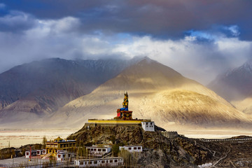 The Maitreya Buddha statue with Himalaya mountains in the background from Diskit Monastery or...