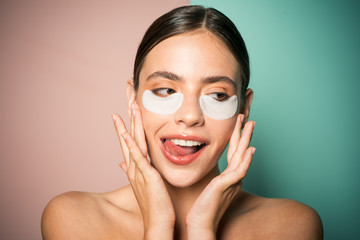 Under eye patches for dark circles and puffiness. Taking care of her skin. Pretty woman using eye patches spending time at home. Daily pampering routine. Modern cosmetics. Eye patches concept