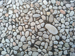 Gravel floor texture background. Floor background with stones. Rocks on the path for health. Round stone floor background.