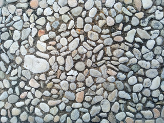 Gravel floor texture background. Floor background with stones. Rocks on the path for health. Round stone floor background.
