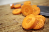 Macro Sliced carrots, vegetable preparation, slicing carrots on wooden board 