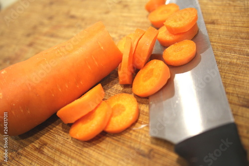 Macro Sliced carrots, vegetable preparation, slicing carrots on wooden board 