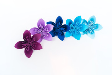 Origami kusudama flower stands in a row against a white background. Rainbow color.