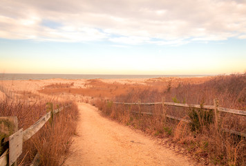 Sandy path leads to ocean in Cape May, NJ, at sunrise