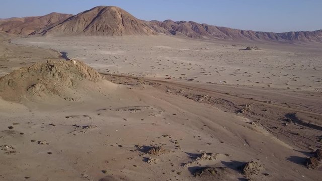 Las Tortolas beach aerial footage at Atacama Desert the sunset ray lights illuminate this amazing and idyllic beach in the desert, an arid awe landscape full of sand dunes, an idyllic destination