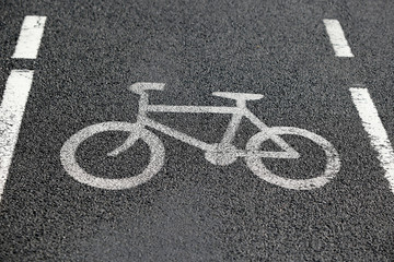 Naklejka na ściany i meble Bike lane. Road sign Bicycle on road. Bike path. Print on surface bitumen