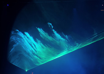 Performance moving LED Par lighting on construction light beam ray downward in blue color with Laser smoke graphic, on Concert and Fashion Show stage ramp, low light exposure with grain and noise