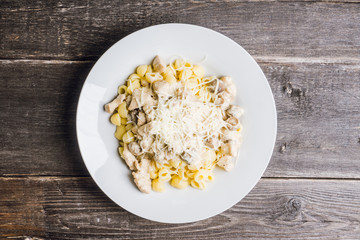Fresh pasta with chicken, mushrooms and cheese on the rustic background. Selective focus.
