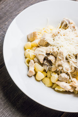 Fresh pasta with chicken, mushrooms and cheese on the rustic background. Selective focus.