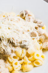 Fresh pasta with chicken, mushrooms and cheese on the rustic background. Selective focus.