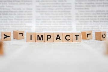 Impact Word Written In Wooden Cube - Newspaper