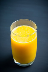 Fresh squeezed orange juice on the rustic background. Selective focus. Shallow depth of field. 