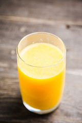 Fresh squeezed orange juice on the rustic background. Selective focus. Shallow depth of field. 