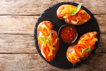 Spicy cajun fillet chicken baked with cheese and bell pepper close-up on a board. horizontal top view