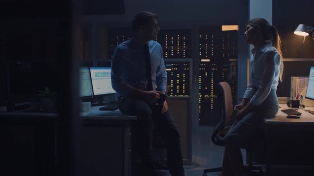 Late at Night in the Corporate Office Two Young Professionals Chatting Friendly, Exchanging News, Talking about Job, Flirting