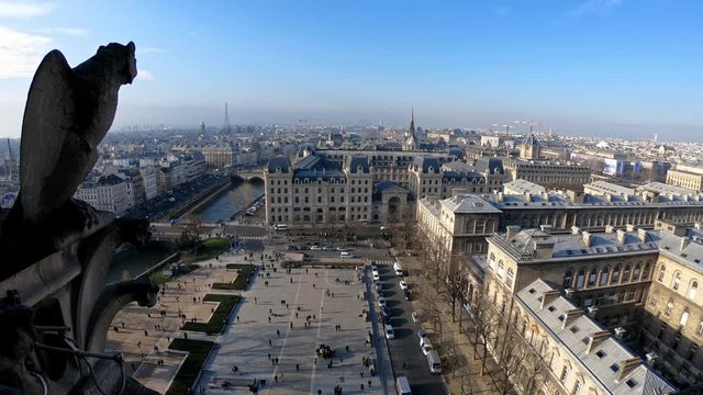 4K, Famous gargoyle statue in Notre Dame Cathedral with city of Paris background. Stone chimera watch over Paris, France. Famous touristic places and popular travel destinations of Europe