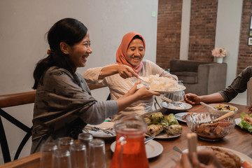 muslim people passing food during fasting dinner together