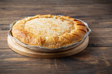 Traditional Greek cheese pie on wooden background