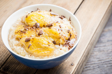 Oatmeal with roasted bananas and chocolate. Selective focus. Shallow depth of field.