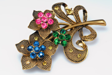 yellow metal brooch decorated with rhinestones isolated on white background, jewel