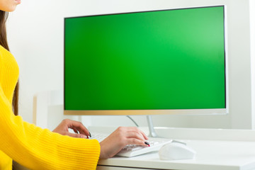 Women's hands close up, working at the computer with green screen, in an office environment
