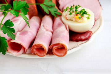 Plate with sliced ham and stuffed eggs.