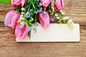 Bouquet of pink tulips, lily of the valley and forget me not flowers.