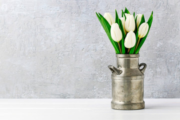 Bouquet of white tulips in vintage silver can.