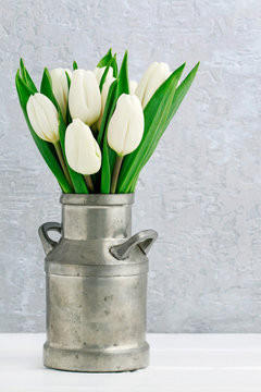 Bouquet of white tulips in vintage silver can.