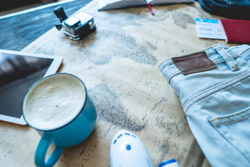 Air tickets, passport, camera, tablet, jeans and map on the table. Gathering for a trip or travel to meet adventures.