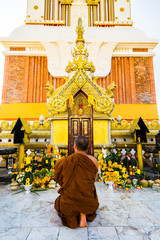 statue of buddha in temple and a monk