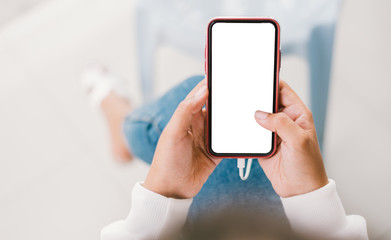 Young Asian woman using smartphone (white screen) at coffee shop. technology and bussiness concept background.