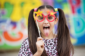 Fun young girl sticking out her tongue - obrazy, fototapety, plakaty