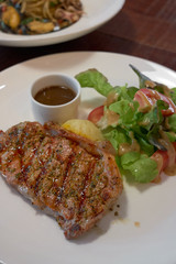 Barbecue Beef Steaks medium rare with grilled potaoes and vegetables.