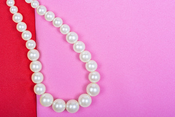 Background of red and pink fabric, the necklace from the pearls. Place for text, top view, Lay Flat, Copy space.