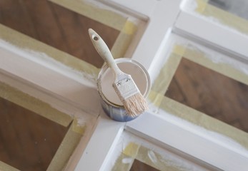 top view of paint brush on white color can. wooden door painting.